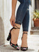 Black floral-heeled shoes worn with rolled-up jeans.