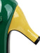 Close-up of a green and yellow high-heeled shoe with a black sole.
