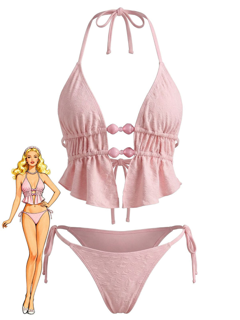 Un ensemble bikini triangle rose pâle orné de volants sur le haut et le bas, avec des perles rondes décoratives au niveau de la poitrine.