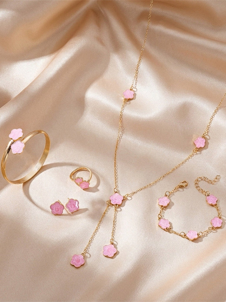 Pink jewelry set with pink gemstones on a beige fabric background