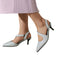 Silver glitter high heels worn with a light purple skirt on a white background