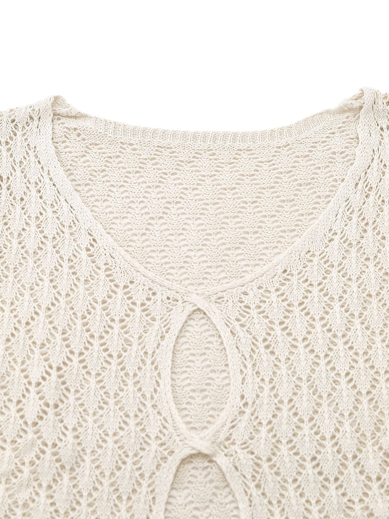 Close-up of the intricate oval cut-out detailing and V-neckline on a cream crochet tunic.