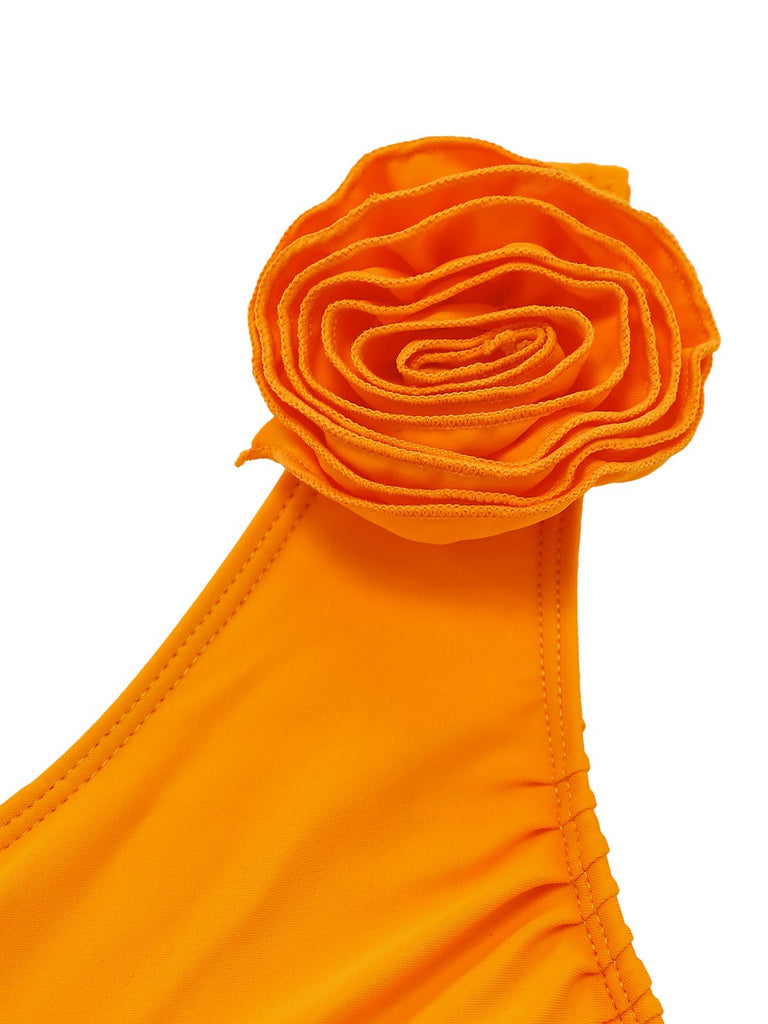 Orange bikini top with a floral design on a white background