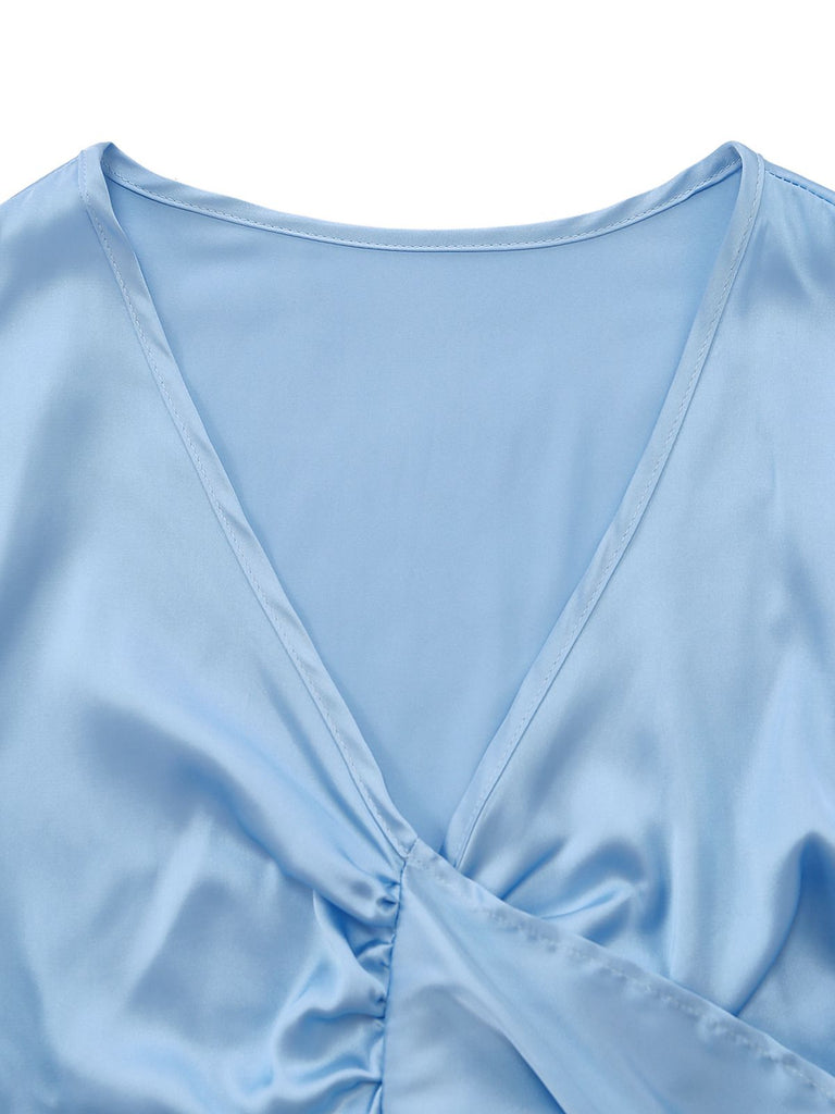 Close-up of the elegant deep V-neckline and smooth satin fabric of the light blue cropped lounge top