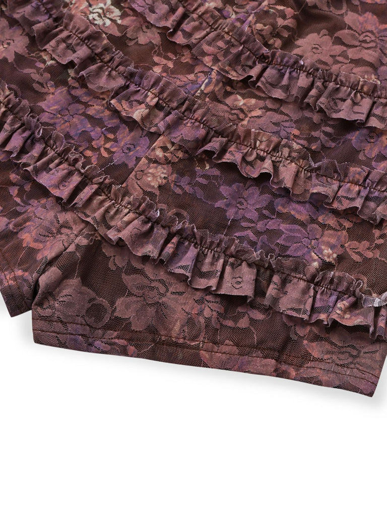 Detailed shot of the intricate tiered lace ruffles and scalloped edges on the hem of the romper.